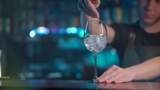 Бармен смешивает лёд для коктейля с аперолом в ночном клубе — стоковое видео