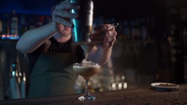 Hipster barista gece kulübünde lüks espresso martini kokteyli hazırlıyor.