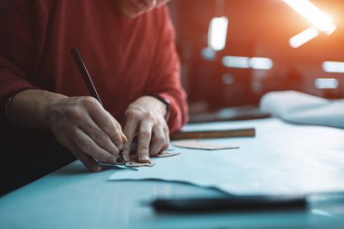 Fabrikada bıçakla ayakkabı için deri şekillendiren adam.