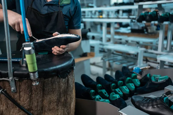 Uomo che lavora con macchinari automatici sulla fabbrica di scarpe — Foto Stock