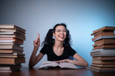 Genç kız evde çok ilginç bir kitap okuyor.