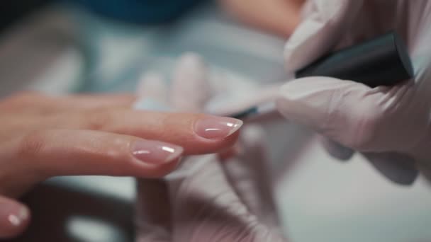 Artista de manicura haciendo esmalte de uñas con cepillo y herramientas — Vídeo de stock