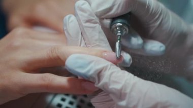 Profesyonel usta manikür salonunda tırnaklarını parlatıyor.