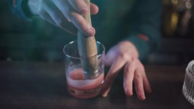 Barmen viski ve portakallı geleneksel kokteyl hazırlıyor.