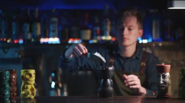 Kahveci likör ve meyve suyuyla egzotik kokteyl hazırlıyor.