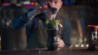 Kahveci likör ve meyve suyuyla egzotik kokteyl hazırlıyor.