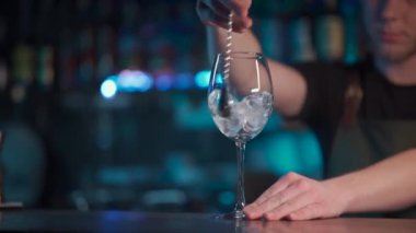 Gece kulübünde aperol spritz kokteyli için buz karıştıran barmen.