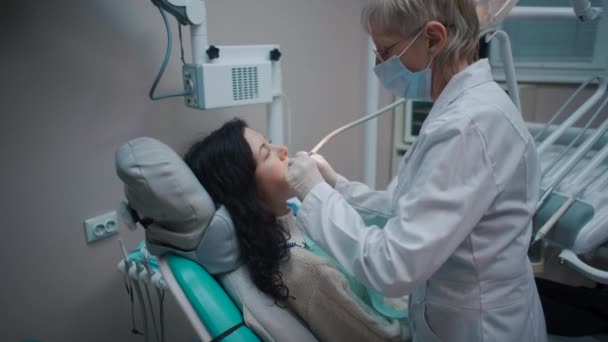 Profissional dentista mulher verificar dente de jovem morena feminina — Vídeo de Stock