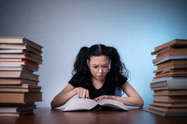 Genç kız evde çok ilginç bir kitap okuyor.