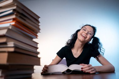 Genç kız evde çok ilginç bir kitap okuyor.