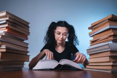 Genç kız evde çok ilginç bir kitap okuyor.