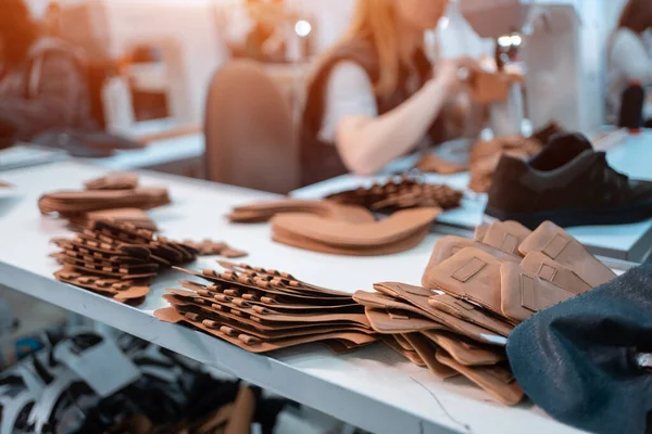 Жінка працює з швейними машинами на взуттєвій фабриці — стокове фото