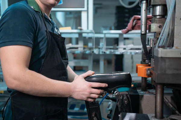 Uomo che lavora con macchinari automatici sulla fabbrica di scarpe — Foto Stock