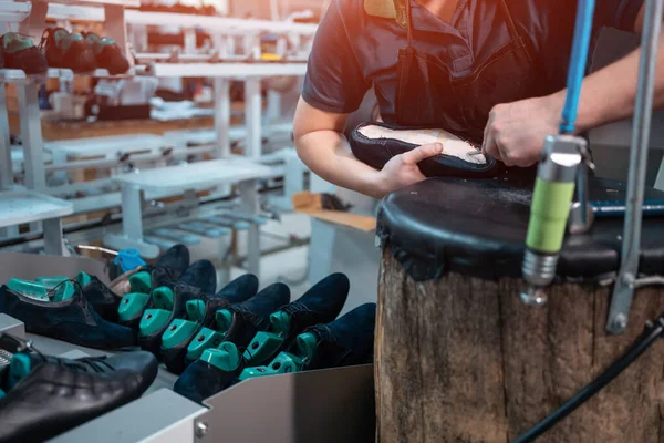 Uomo che lavora con macchinari automatici sulla fabbrica di scarpe — Foto Stock