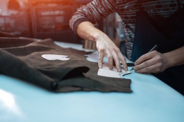 Fabrikada bıçakla ayakkabı için deri şekillendiren adam.