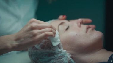 Kozmetik uzmanı beyaz süngerle temiz kadın yüzü
