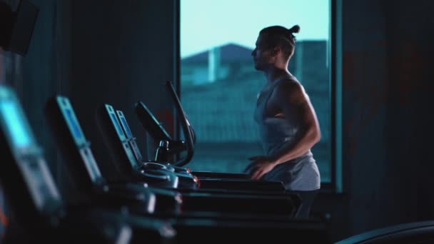 Guapo activo hombre corriendo en cinta de correr en moderno gimnasio — Vídeos de Stock