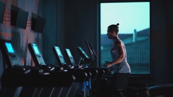 Όμορφος ενεργός άντρας τρέχει σε διάδρομο στο σύγχρονο γυμναστήριο — Αρχείο Βίντεο