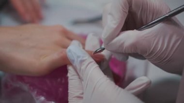 Yakın çekim ve manikür sanatçısı tırnak temizleme ve cilalama yapıyor.