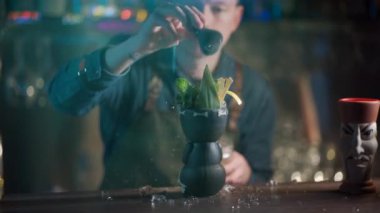 Kahveci likör ve meyve suyuyla egzotik kokteyl hazırlıyor.