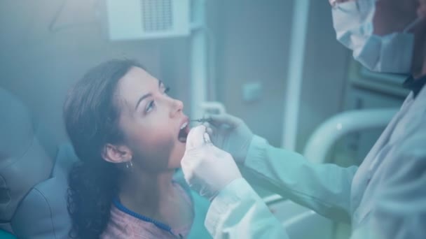 Όμορφη μελαχρινή σγουρή γυναίκα οδοντίατρος θεραπεία ασθενή στη σύγχρονη κλινική — Αρχείο Βίντεο