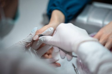 Yakın çekim ve manikür sanatçısı tırnak temizleme ve cilalama yapıyor.