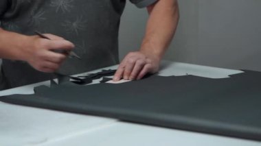 Fabrikada bıçakla ayakkabı için deri şekillendiren adam.