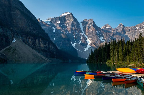 A row of canoes sitting in the evening sun, ready to be taken on the water. Louise lake in Banff national park, Alberta, Canada