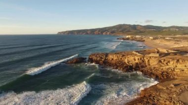 Hava geniş plaj beyaz su dalgalar günbatımı Guincho adlı bir dron gelen kum üzerinde çökmesini ile vurdu