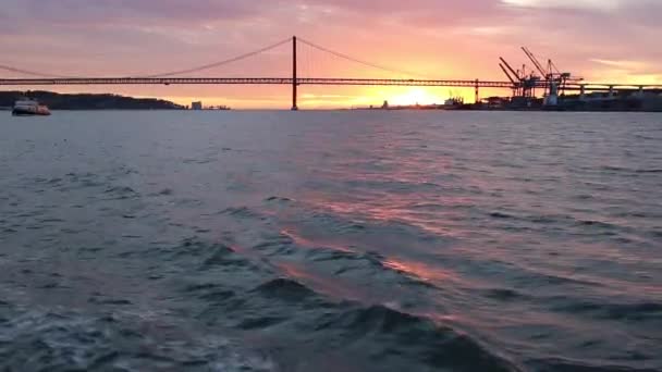 Gouden zonsondergang op de achtergrond van 25 April-brug-Lissabon — Stockvideo