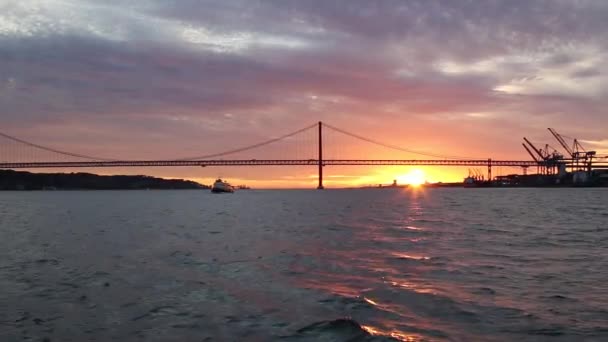 Gouden zonsondergang op de achtergrond van 25 April-brug — Stockvideo