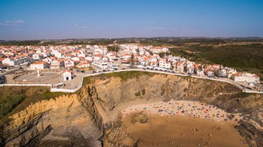 Panoramic view of Zambujeira de Mar and beach with holidaymakers people aerial clipart