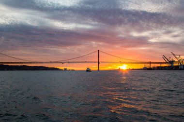 Panoramik manzaralarını sunan Tagus Nehri, köprü 25 Nisan Lizbon ve port adlı gemi, Portekiz günbatımı.