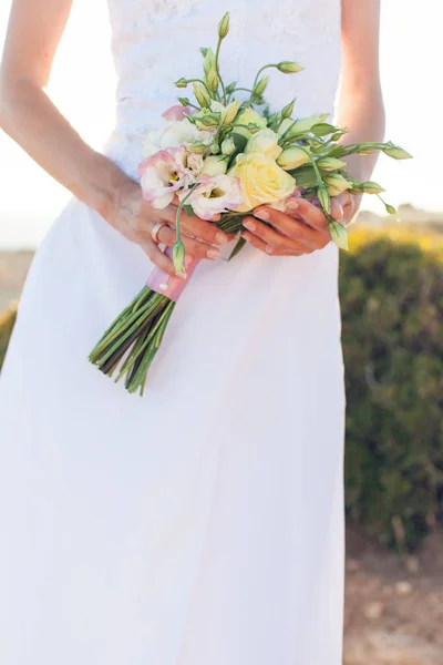 A noiva em um vestido branco segurando belo buquê de casamento de rosas — Fotografia de Stock