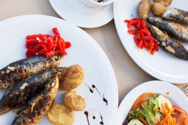 Sebze plakaları ile kızarmış sardalya servis