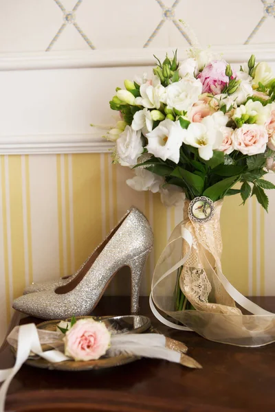 Bruiloft Decoratie: schoenen, ringen en boeket op een tafel — Stockfoto