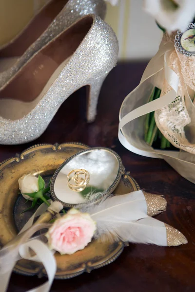 Esküvői dekoráció: cipő, a gyűrűk és a csokor az asztalon — Stock Fotó