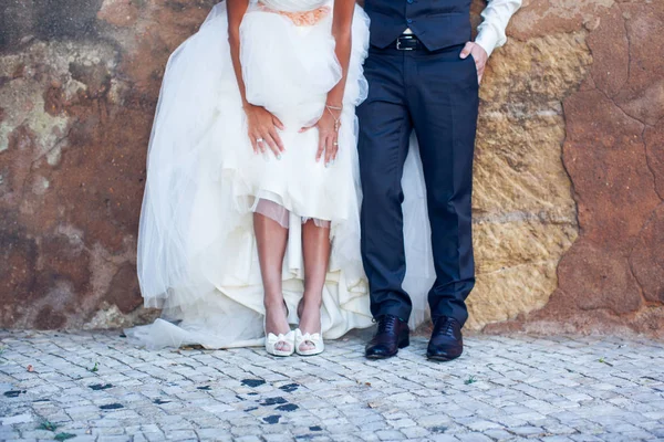 Les jeunes mariés se tiennent sur un trottoir en pierre — Photo