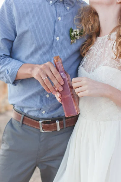Casal jovem segurando uma garrafa com uma mensagem — Fotografia de Stock