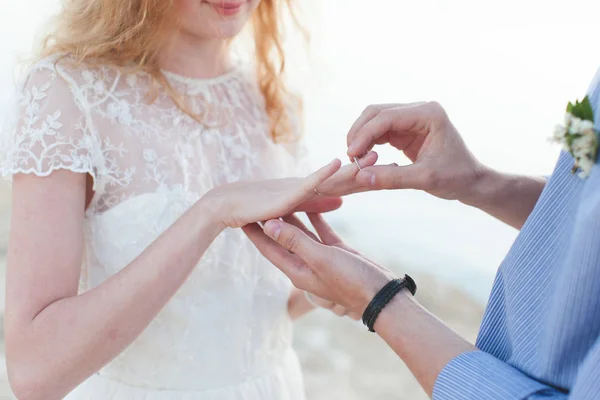 O noivo usa uma aliança de casamento no dedo da noiva close-up — Fotografia de Stock