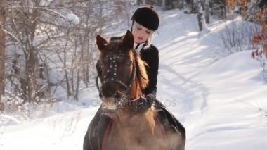 Genç güzel kız jokey ve at kış orman içinde