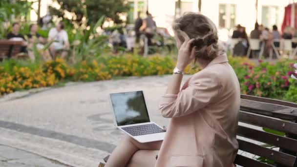 노트북 및 스마트폰 화창한 날 공원에 매력적인 금발 백인 여자 작업 프리랜서 — 비디오