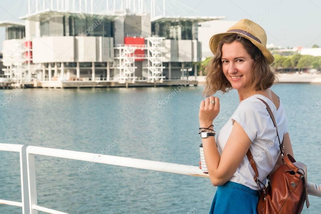 Attractive young woman make photo near Lisbon Oceanarium near river Tagus