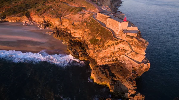 Aerial view of ocean and Nazare lighthouse at sunset, Portugal — Stock Photo, Image