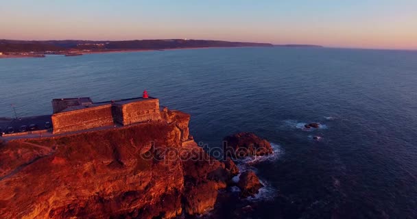 सूर्यास्त, पुर्तगाल में महासागर और नाज़रे लाइटहाउस का हवाई दृश्य — स्टॉक वीडियो