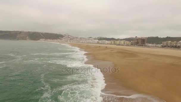 Bela praia de areia oceânica vazia em Nazar, Portugal. Vista aérea — Vídeo de Stock