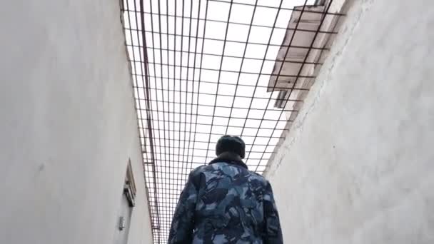 Prison officer walking in inter yard in russian penitentiary colony, jail, prison at winter glidecam — Stock Video