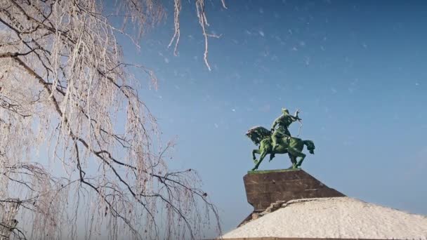 Падіння снігу біля пам'ятника Салават Юлаєв в УФІ взимку прекрасний сонячний день — стокове відео