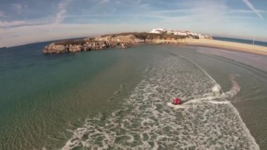 Bir adam Noel Baba kostüm jetsurf üzerinde güzel okyanus kıyısı havadan görünümü sürmek.