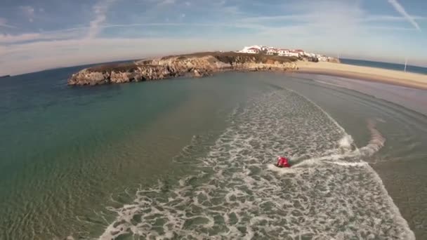 Człowiek w stroju Mikołaja jeździ na jetsurf obok wybrzeża Oceanu piękny widok z lotu ptaka — Wideo stockowe